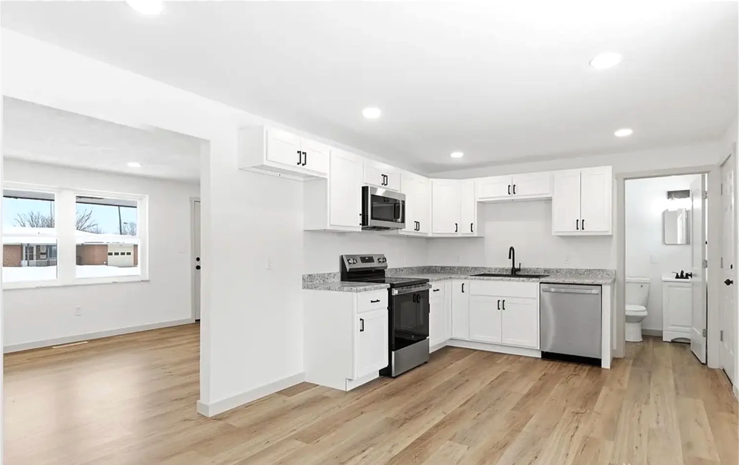Open Concept White Kitchen & Granite Counters